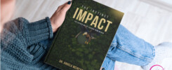 Reader holding The Instinct Impact: The Sacred Art of Leading from Within by Dr. Angela McIntyre, published by Wealthy Sistas Publishing House — a transformational book on mindful, purpose-driven leadership.